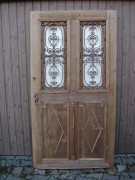 Gründerzeithaustüre mit zwei schmucken Gussgittern und Fensterflügeln